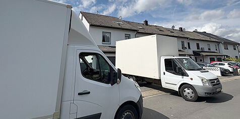 Weisse Fahrzeuge vom HNE Service ohne Werbung die vor einem Haus stehen, bereit zur Entrümpelung in Krefeld