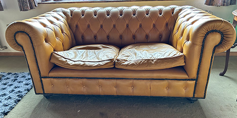 Auf dem Bild ist eine gelbe Couch als Nachlass zu sehen